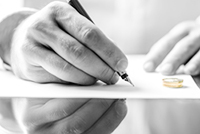 Close-up of a hand, signing a document